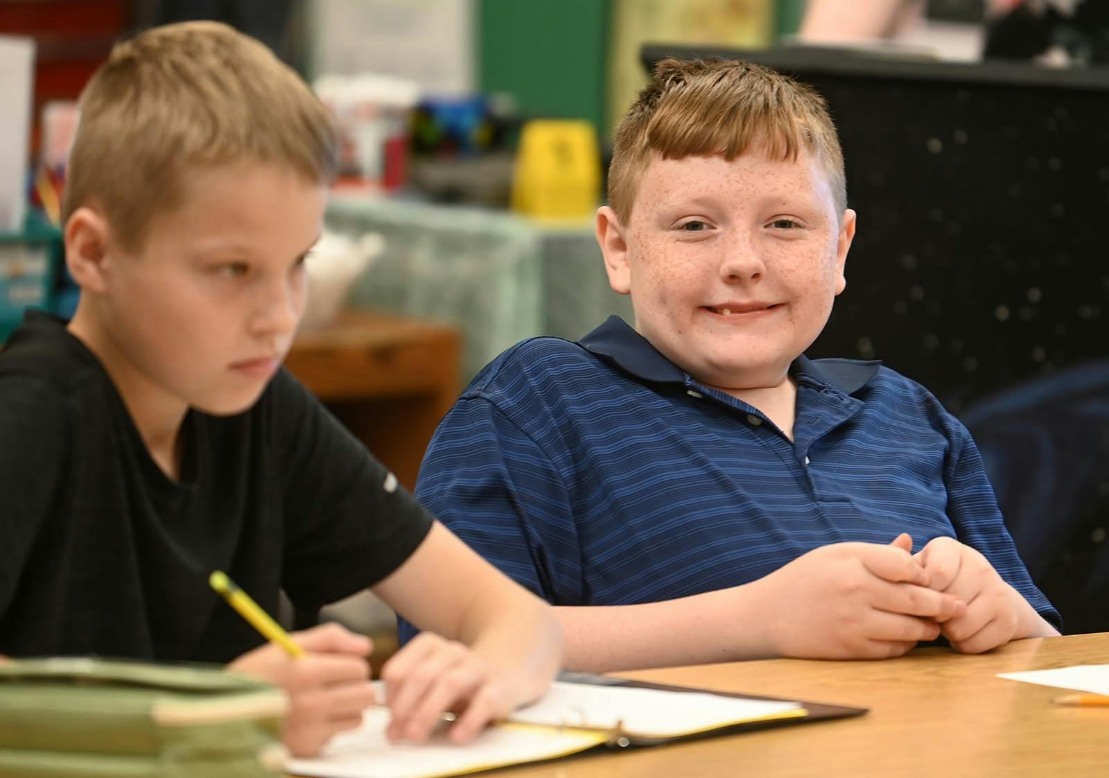 Two children sitting at a desk in a classroom
