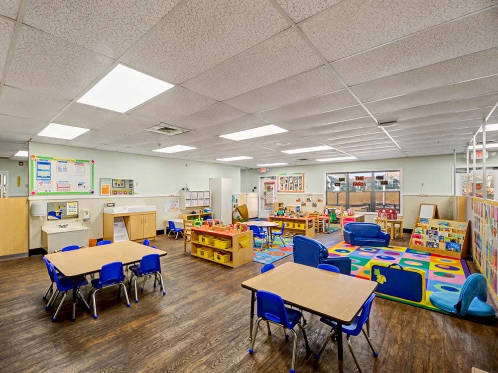 Empty colorful children's classroom with small tables and chairs