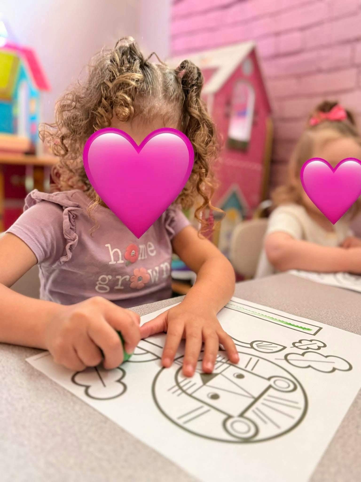 Child coloring at a table with another child