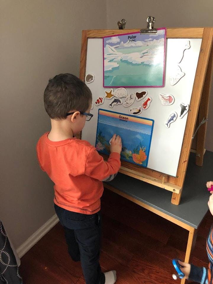 Child playing with magnets on an easel