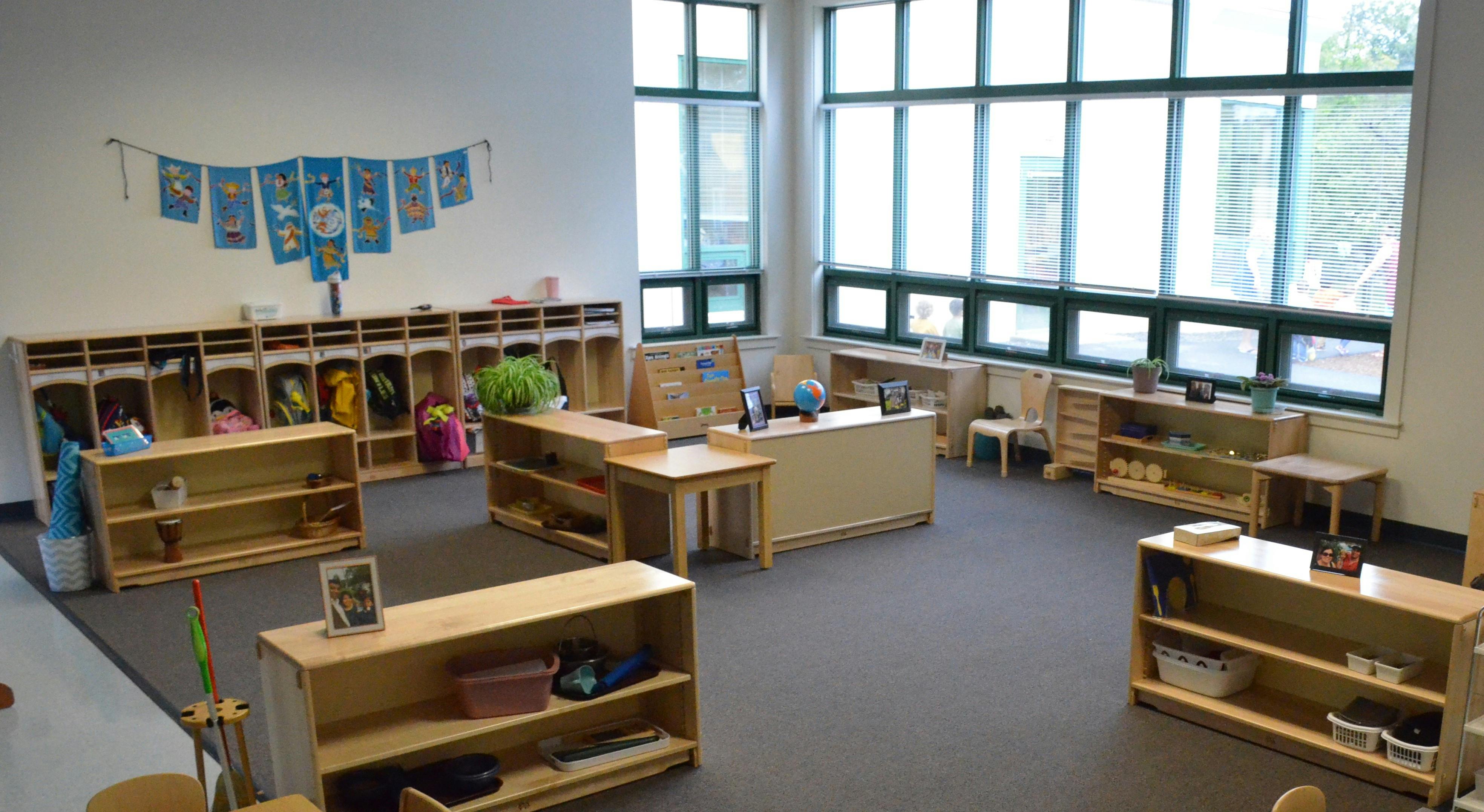 Empty classroom with wooden shelves and large windows