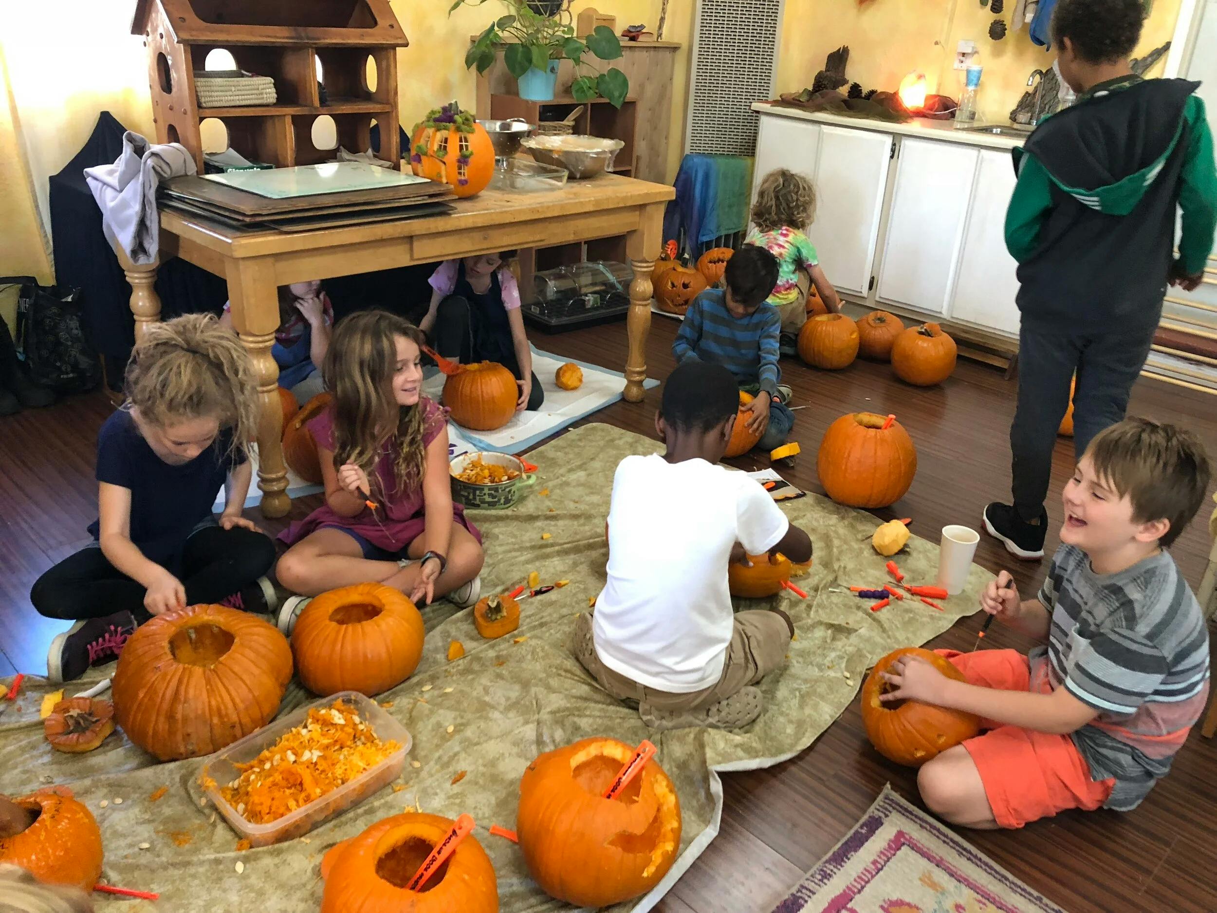 Children carving pumpkins in a classroom setting