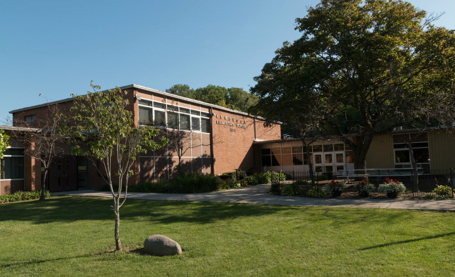 Brick building with many windows and a grassy lawn