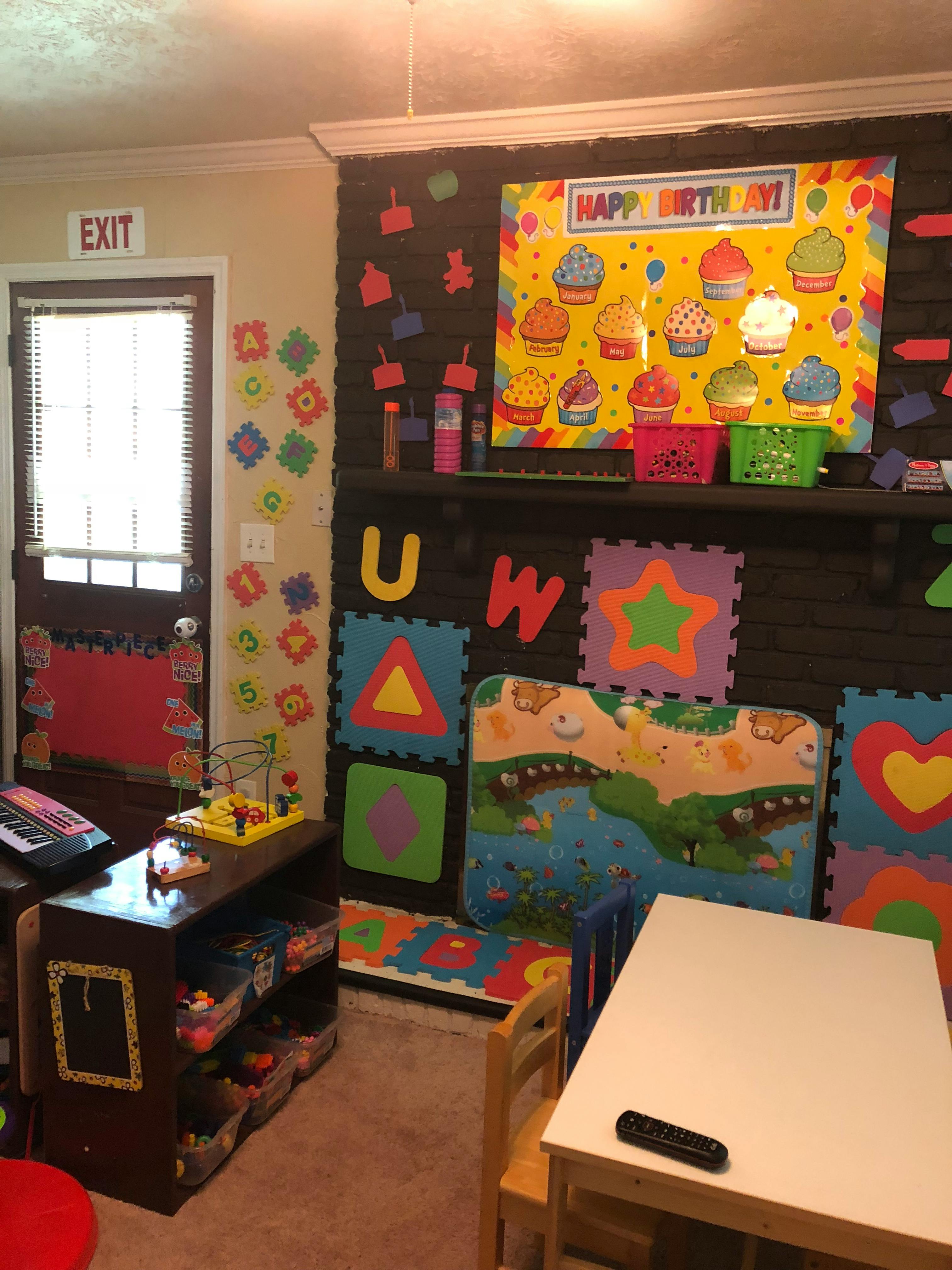 A classroom with a birthday sign, alphabet letters, and play mats