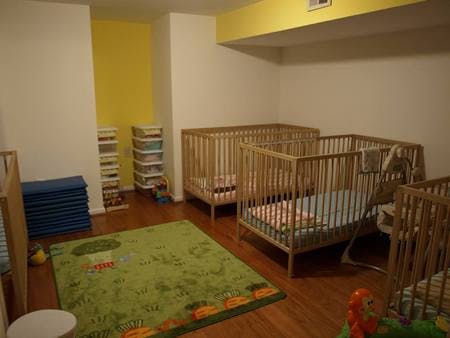 Multiple wooden cribs in a room with a green rug