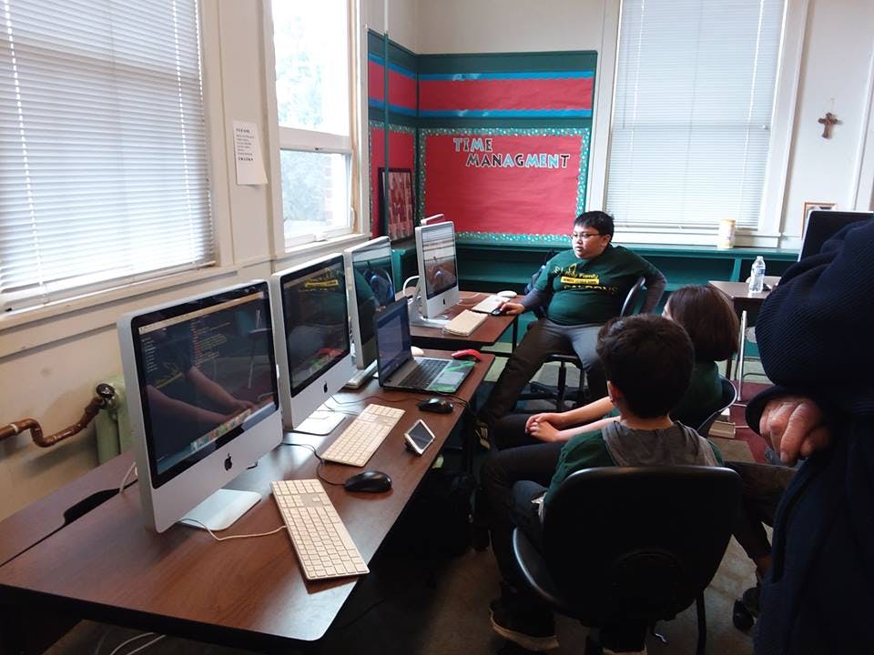 People sitting at desks with computers in a classroom