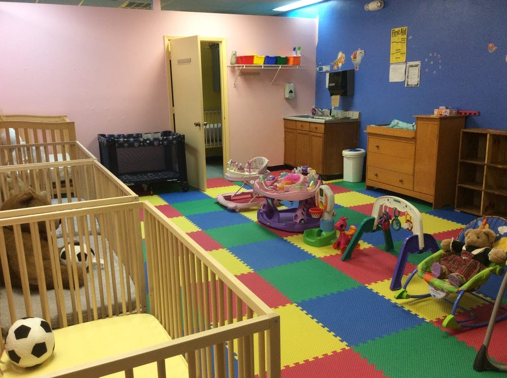 Nursery room with multiple cribs and colorful play mats