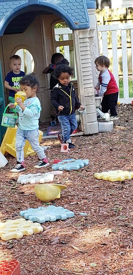 Children playing outdoors near a playhouse