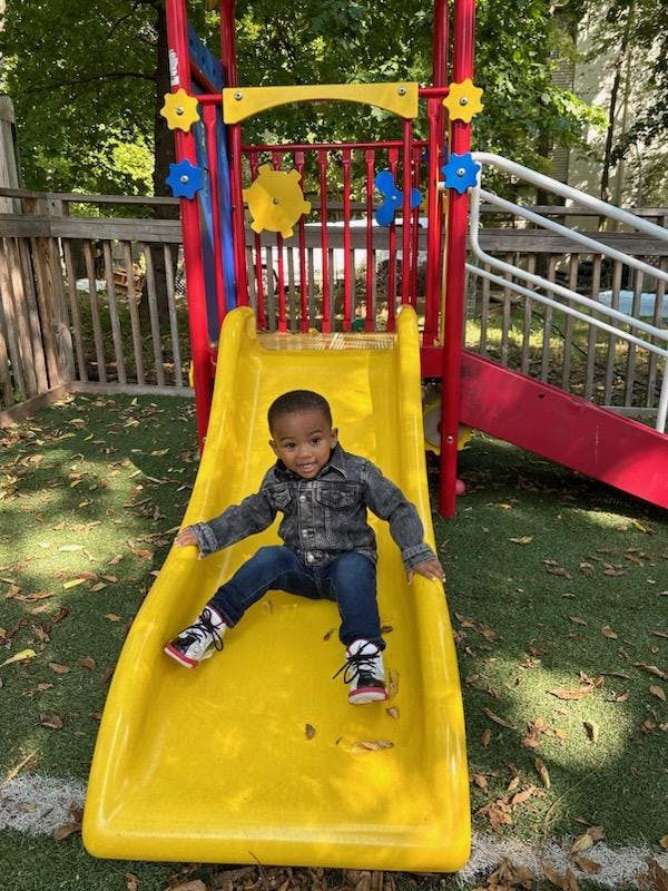 Child on a yellow slide at a playground