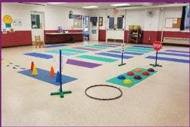 Indoor play area with colorful mats and various play equipment