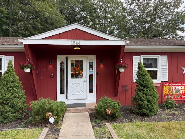 Red building with white trim, a white door, and \