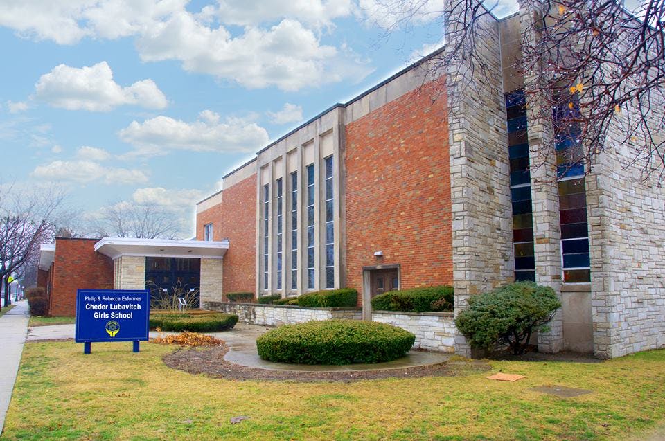 Exterior of a brick and stone building with a blue sign in front