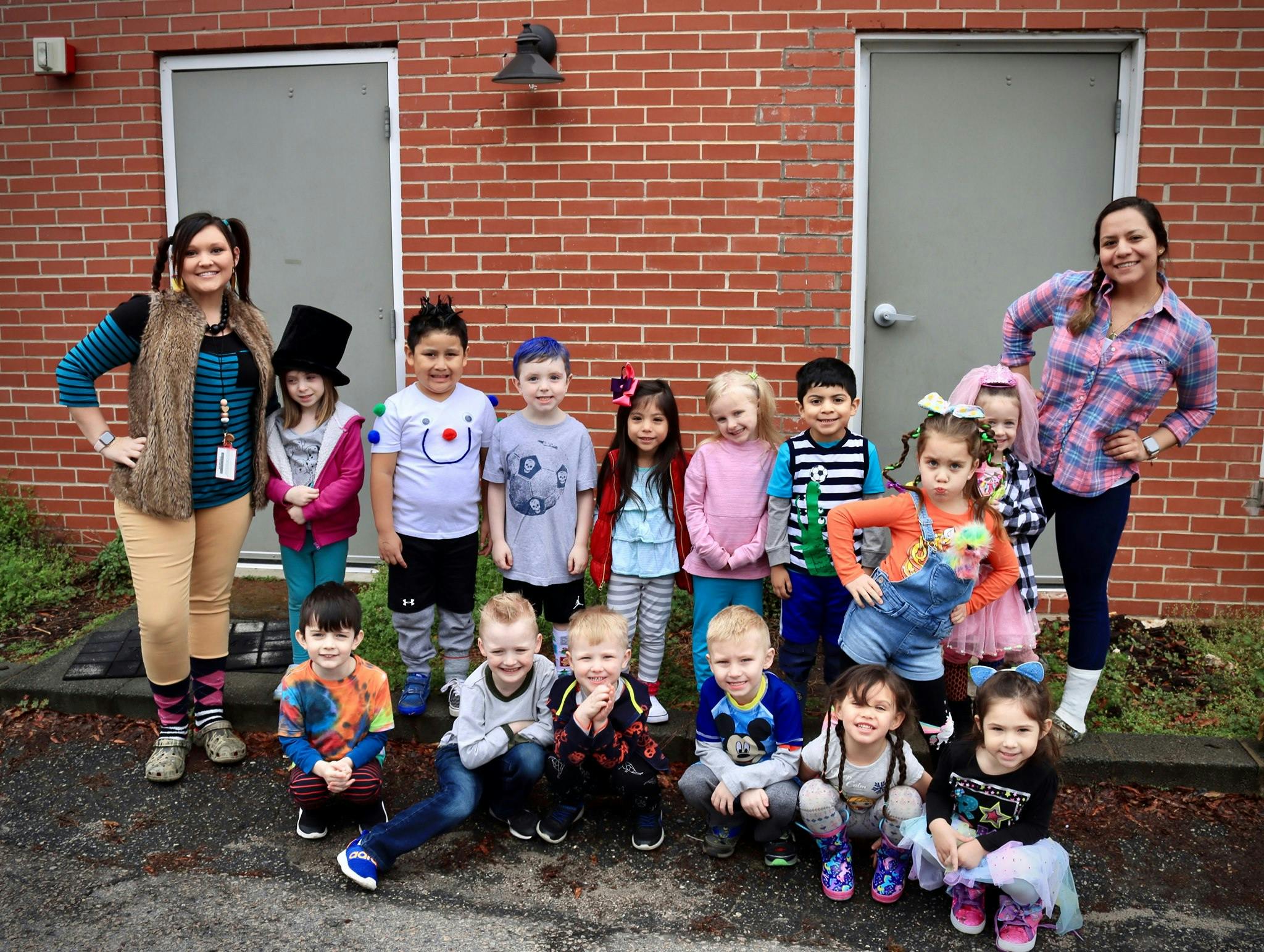 Two people and a group of children posing outdoors