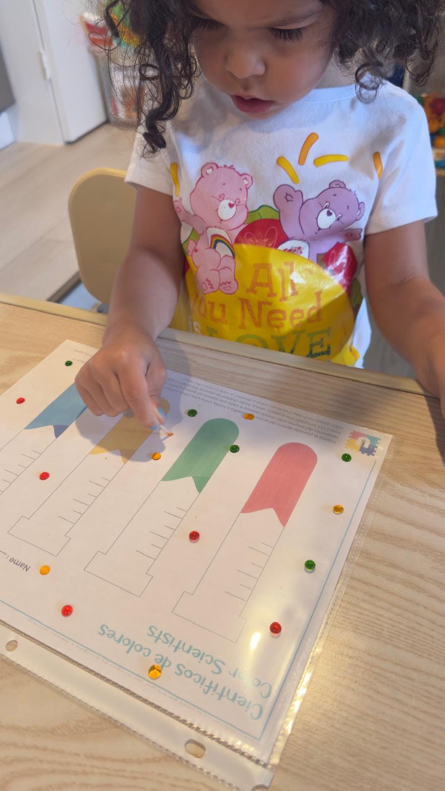 Child placing a small item on a paper with colorful flag designs