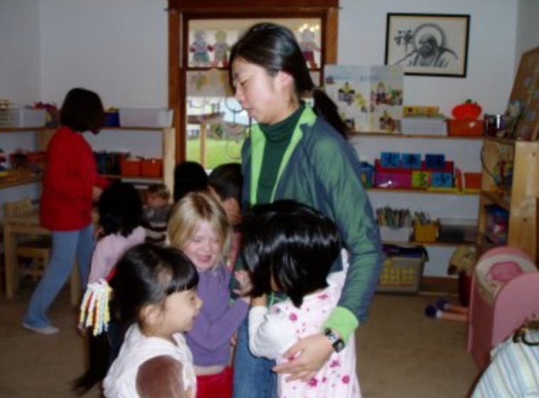 Adult person with several children in a classroom