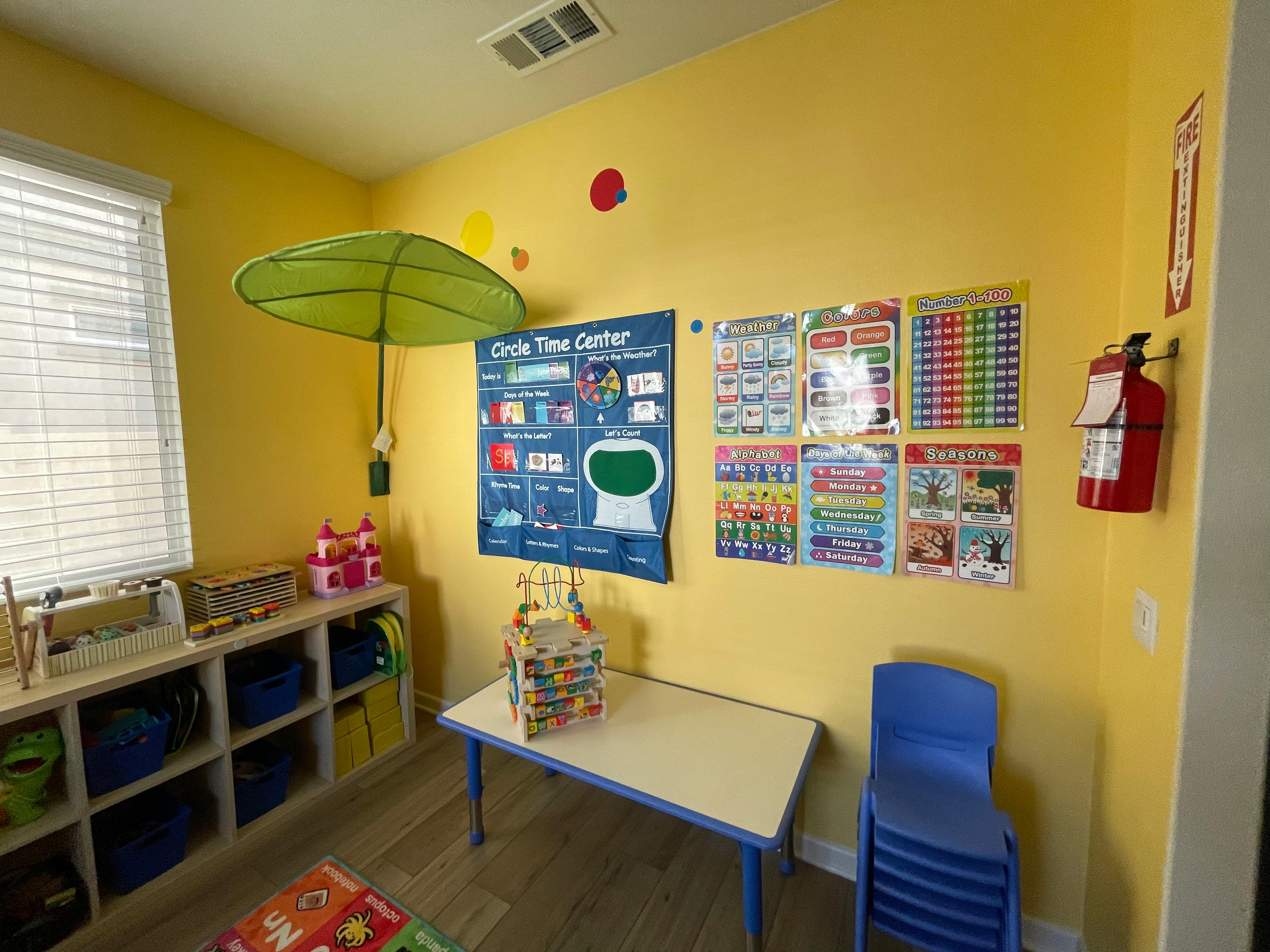 Classroom with educational posters, small table, and chairs