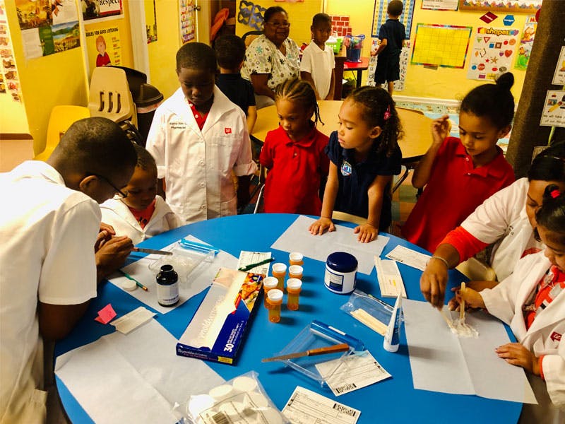 People and children gathered around a table with craft supplies