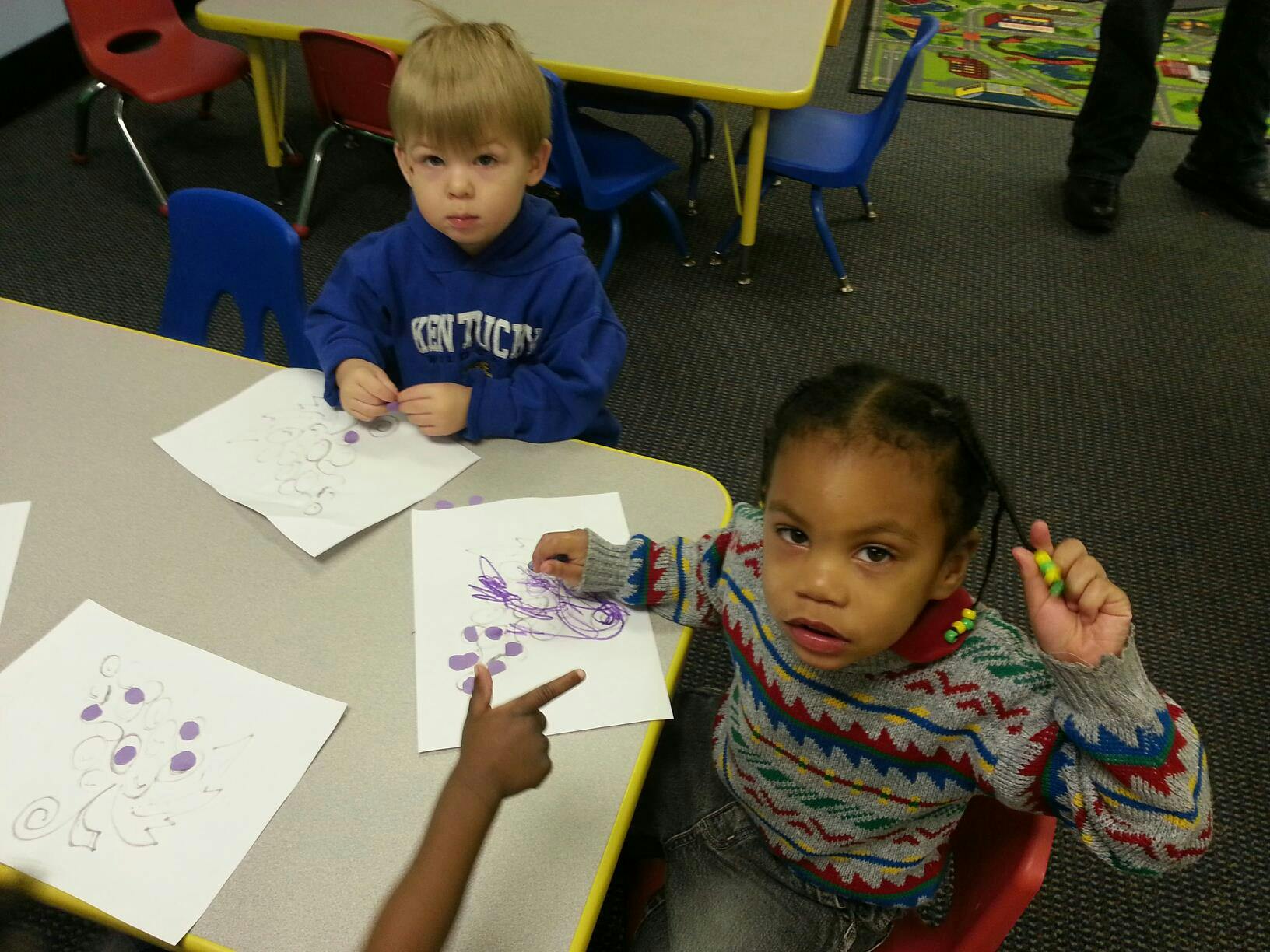 Children drawing at a table in a classroom