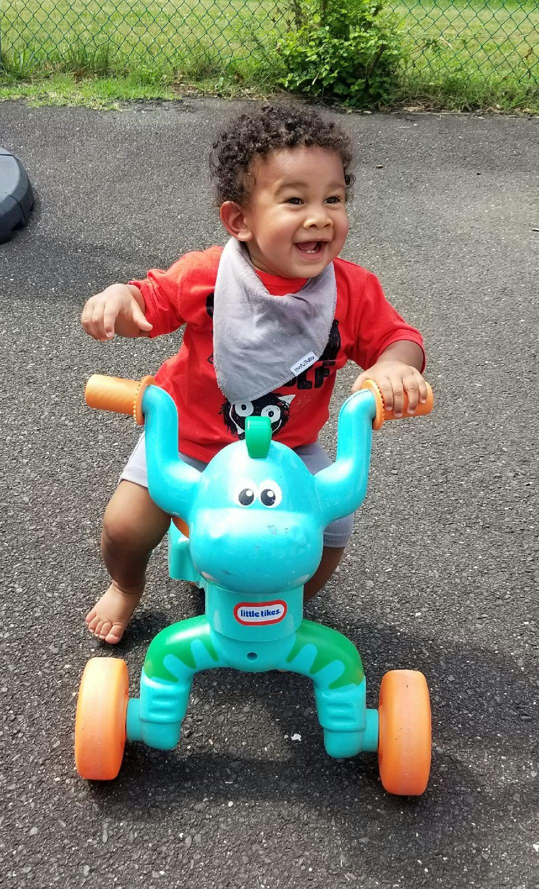 Child on a blue and green ride-on toy