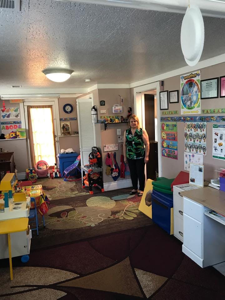 Person standing in a classroom filled with learning materials and toys