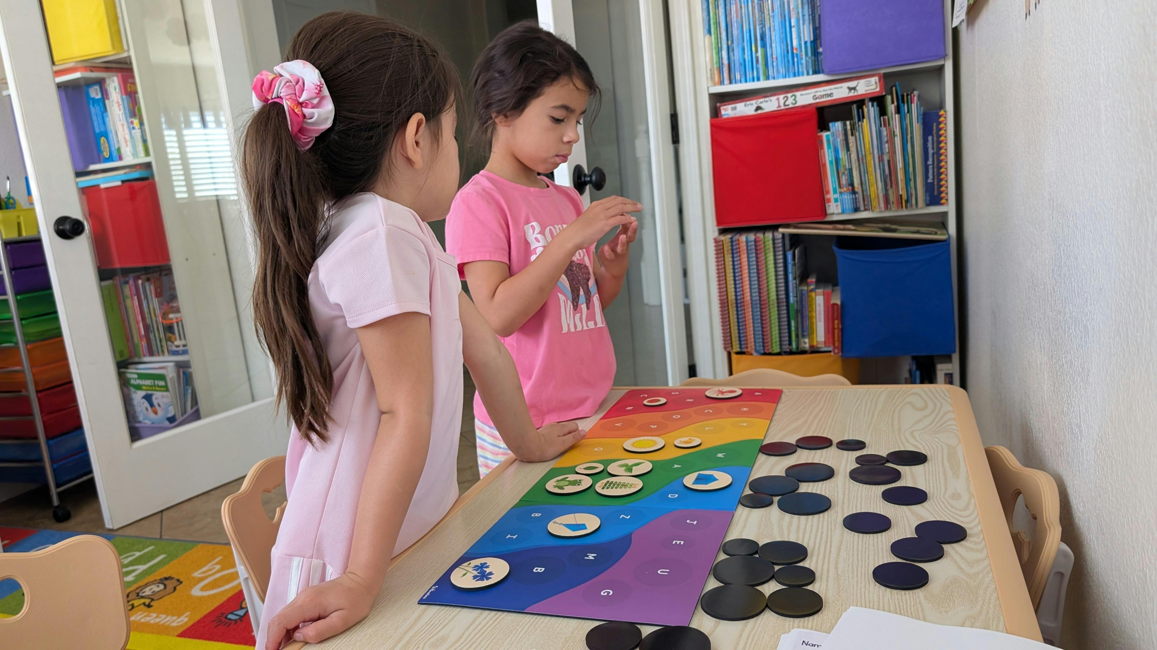 Two children playing a board game at a table
