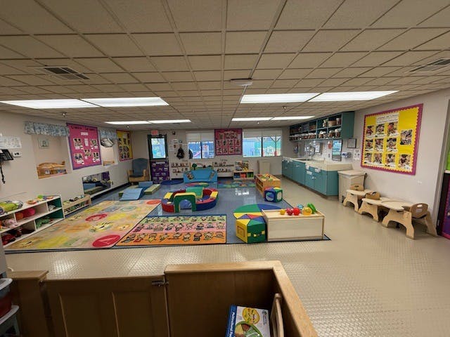 Empty children's playroom with colorful rugs and soft play equipment