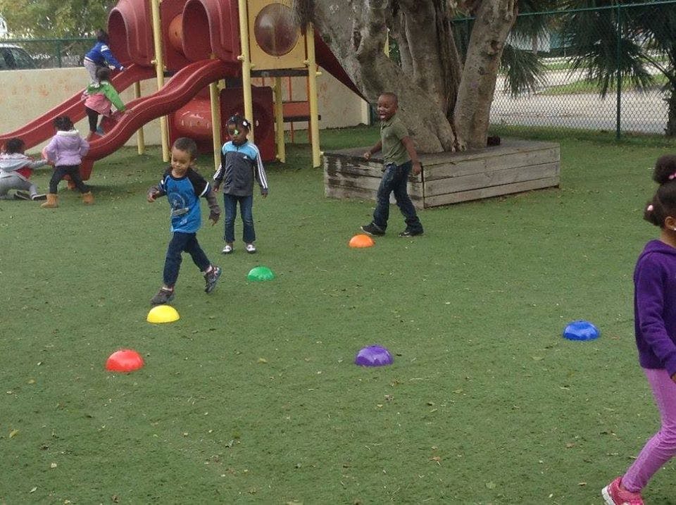 Children playing on a playground with colorful markers on the ground