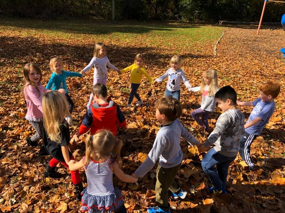 Children holding hands in a circle outdoors