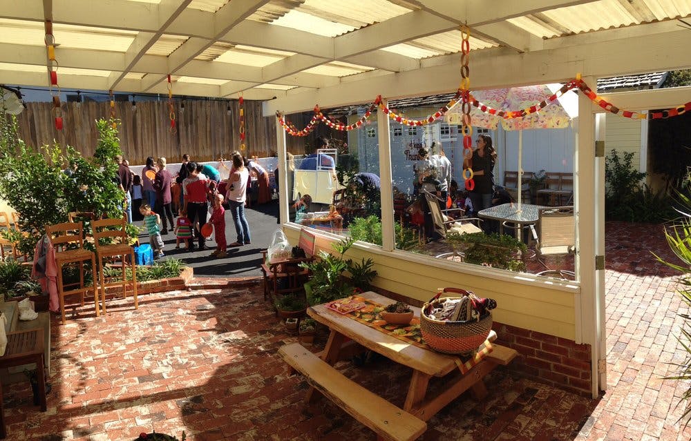 People gathered under a covered patio with a picnic table in the foreground