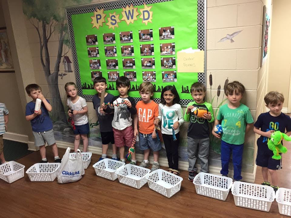 Group of children standing in a line with white baskets