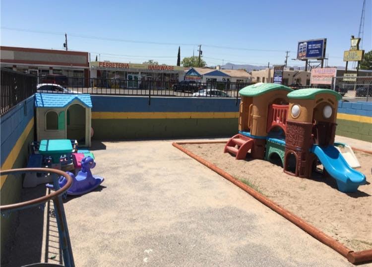 Playground with a playhouse, rocking horse, and a play structure with a slide