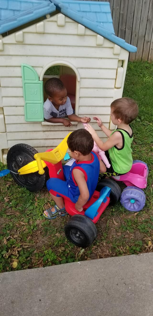 Three children playing with toys outdoors