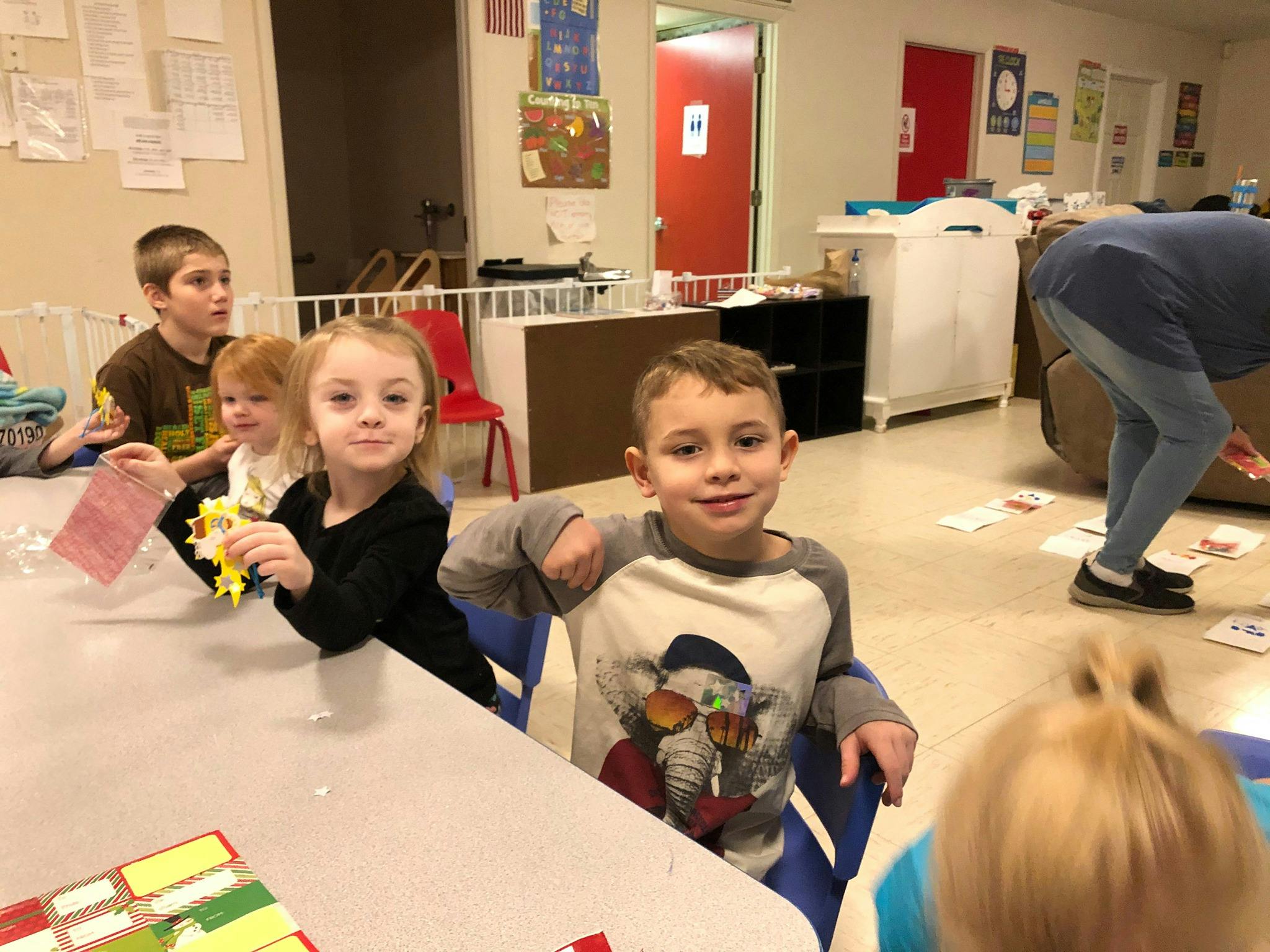 Children sitting at a table in a classroom