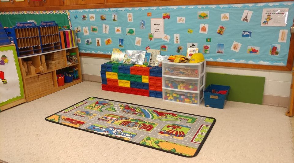 Playroom with a colorful rug, storage shelves, and a bulletin board