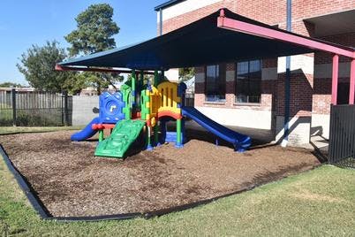 Playground with slides and climbing structure under a shade cover
