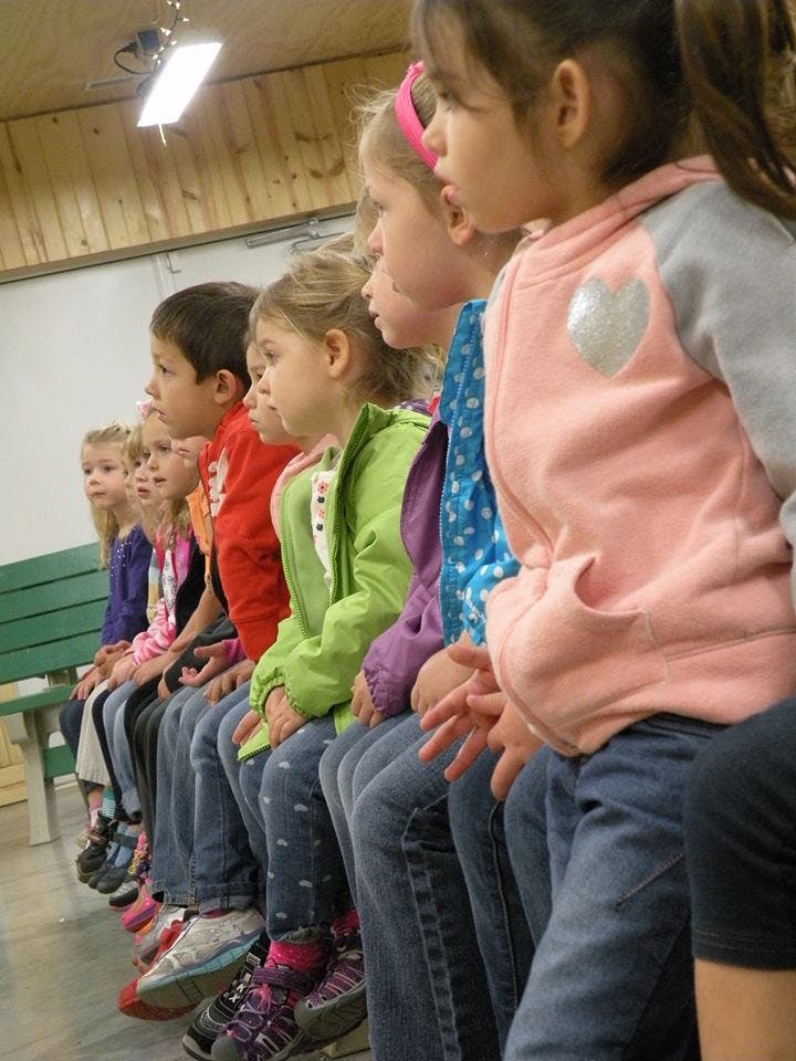 Row of children sitting on a bench