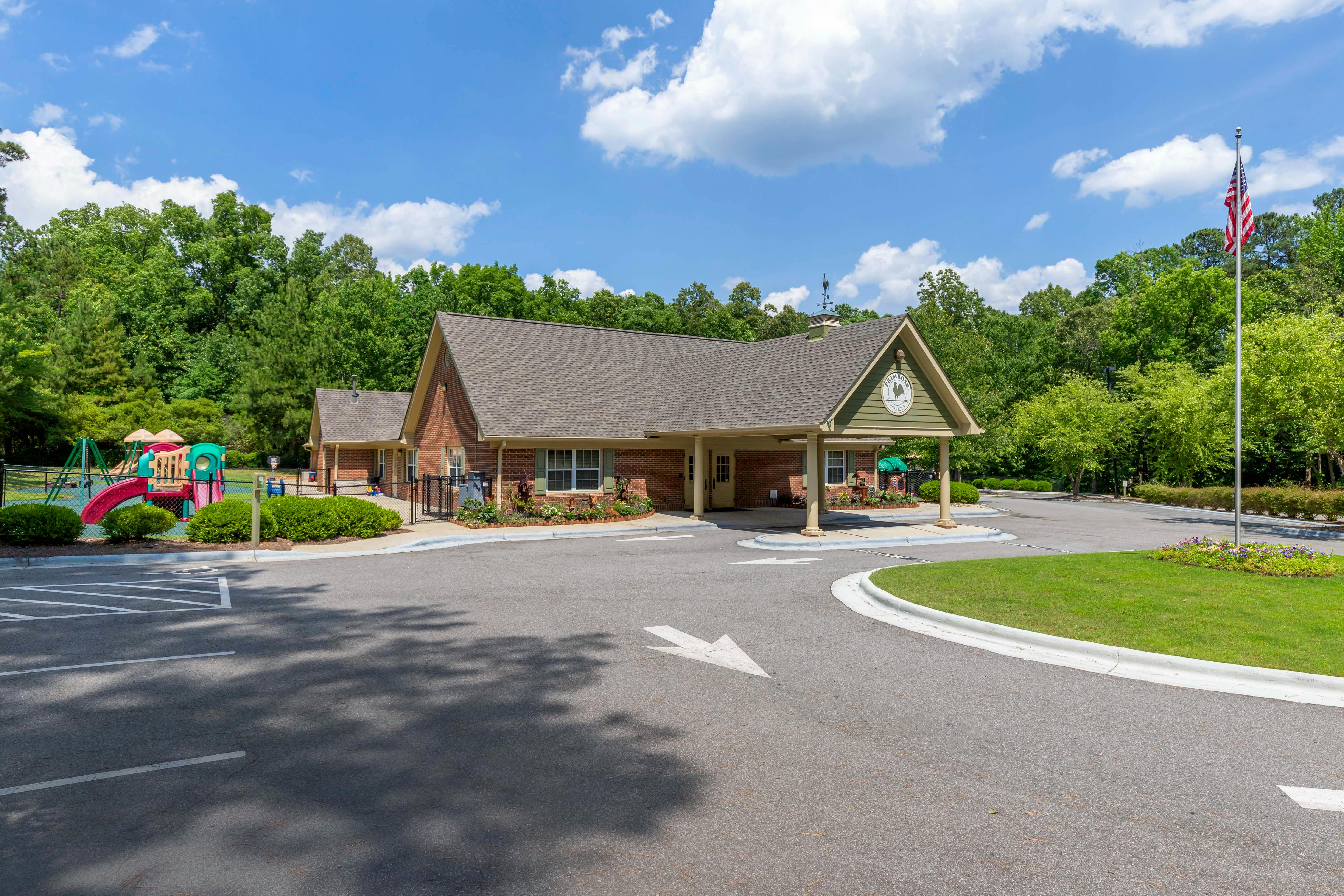 Brick building with a covered entrance, a playground, and an American flag