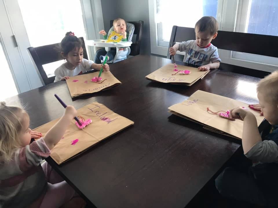 Four children painting at a table