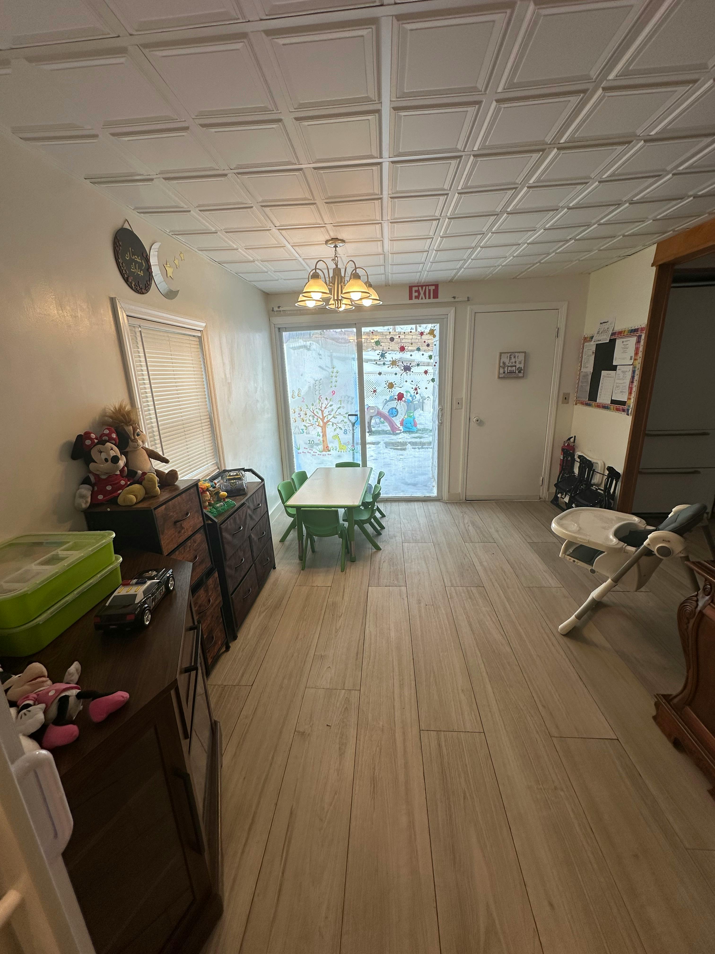 Room with a small table and chairs, dressers, and a glass door