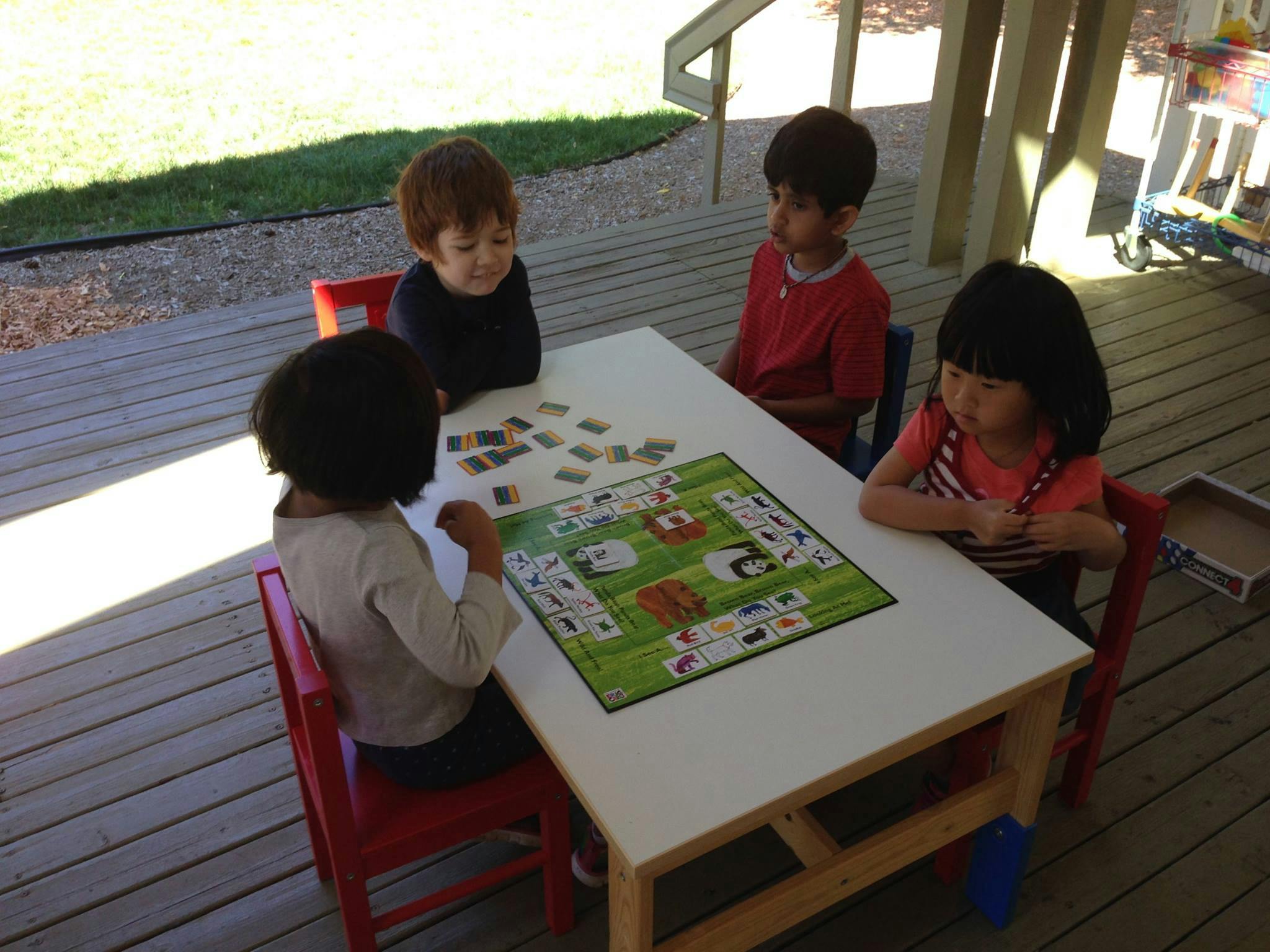 Four children playing a board game at a table