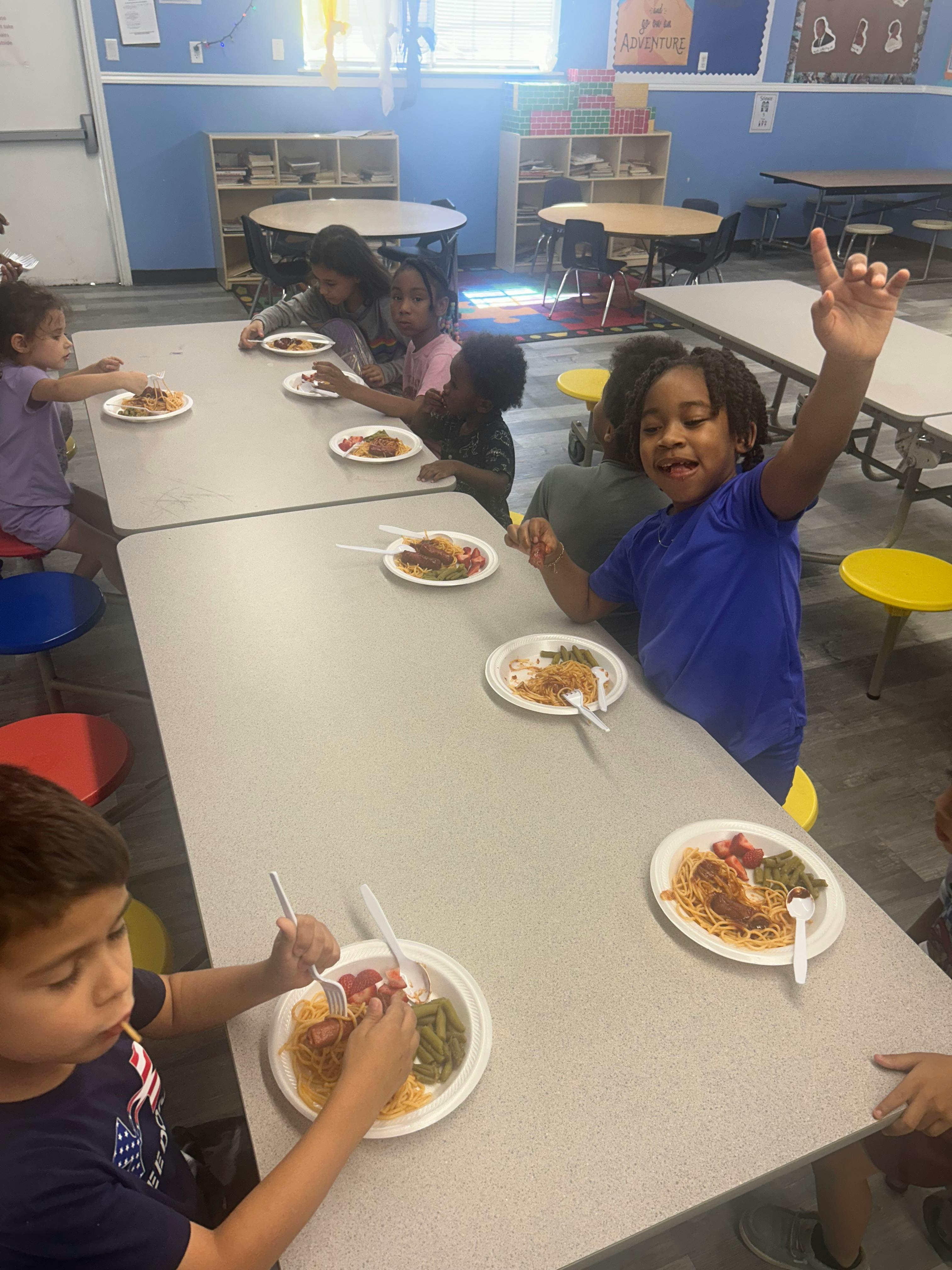Children eating at tables in a classroom