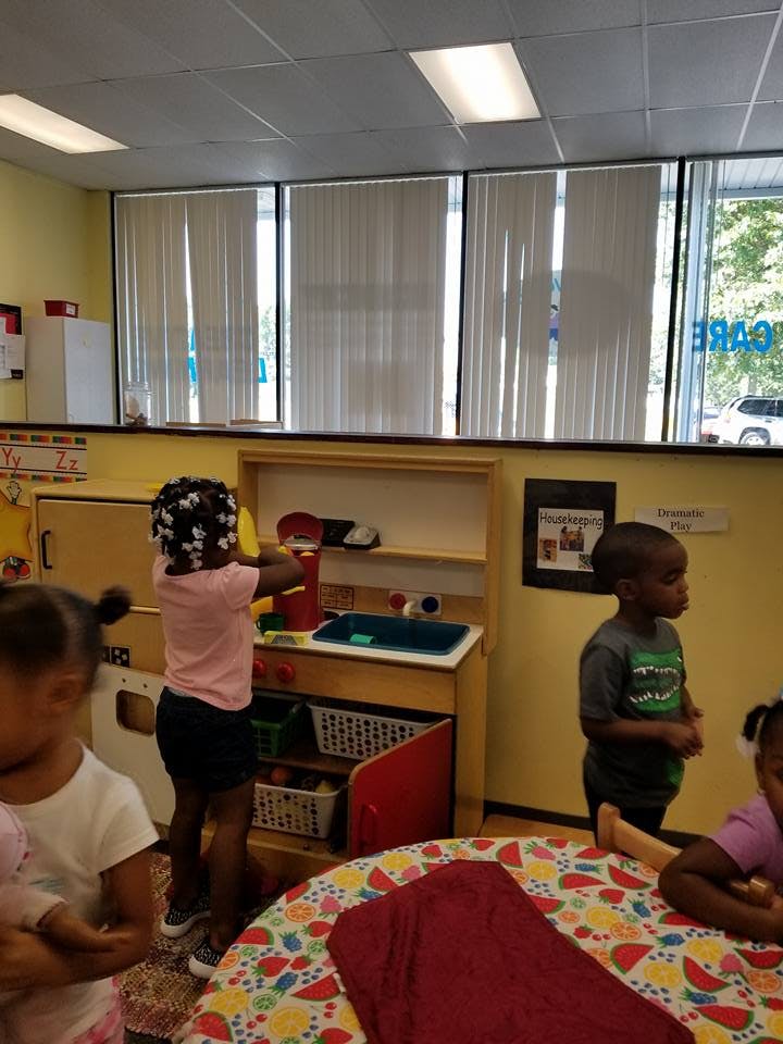 Child playing at a toy kitchen in a classroom