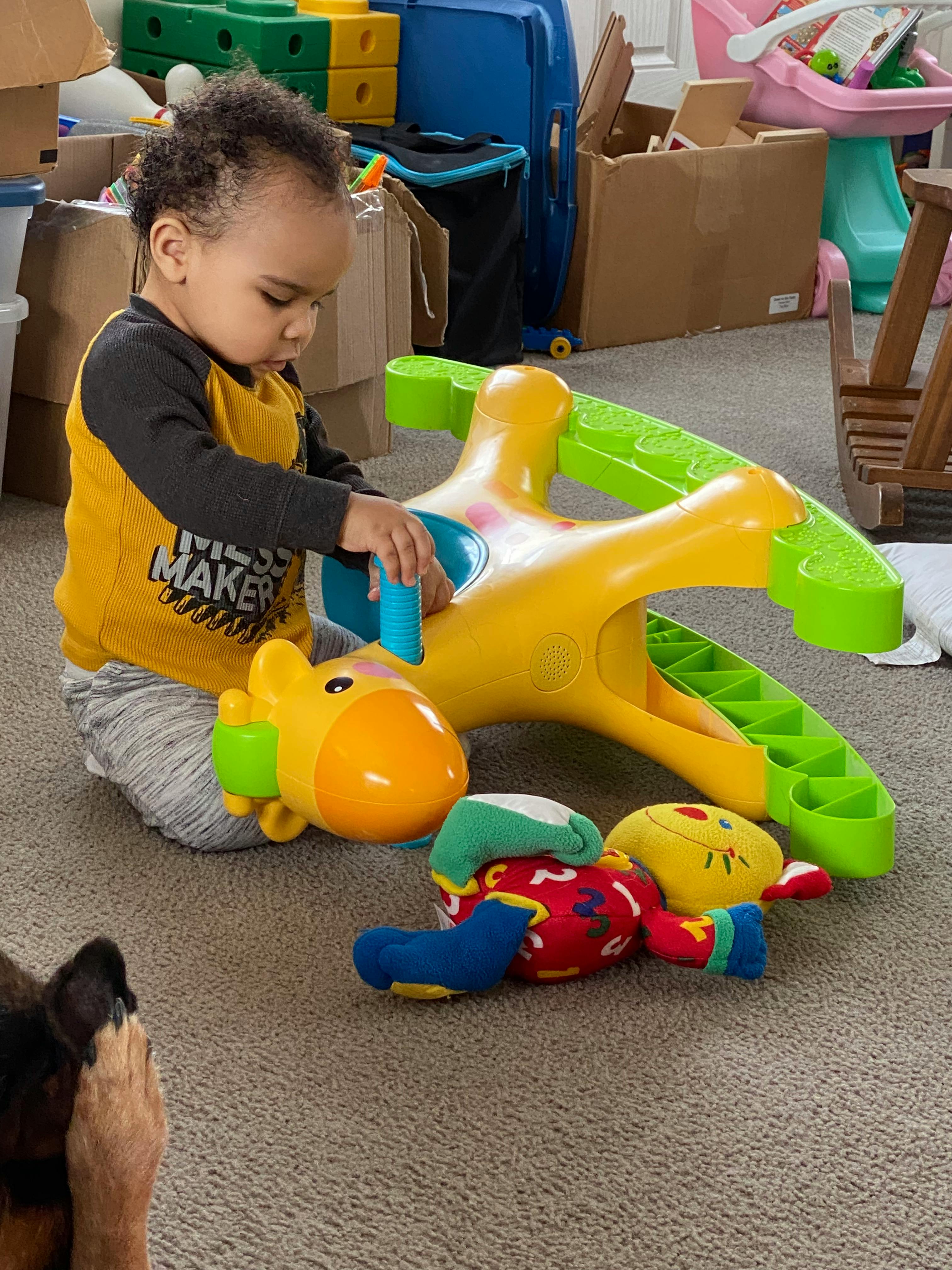 Child playing with a yellow and green toy