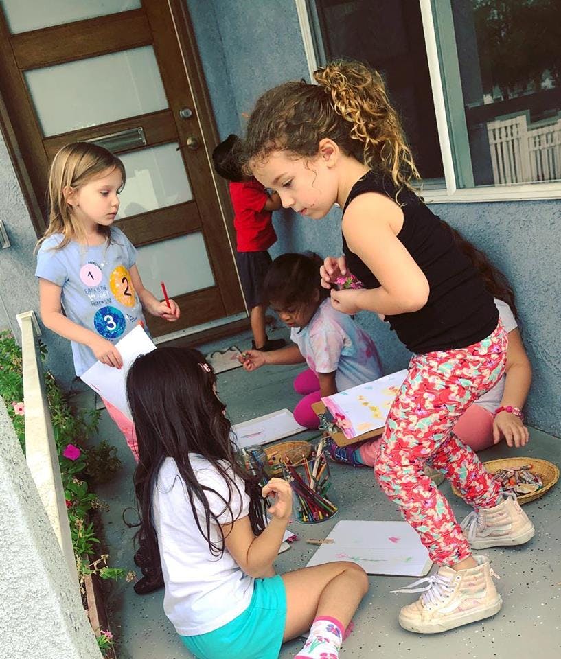 Children drawing and coloring on a porch