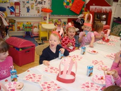 Children sitting at a table with heart-patterned decorations