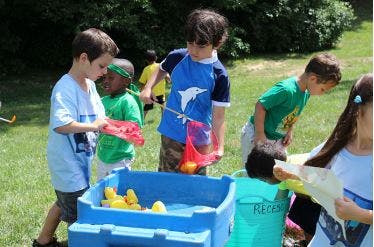 Children playing with water and toys outdoors