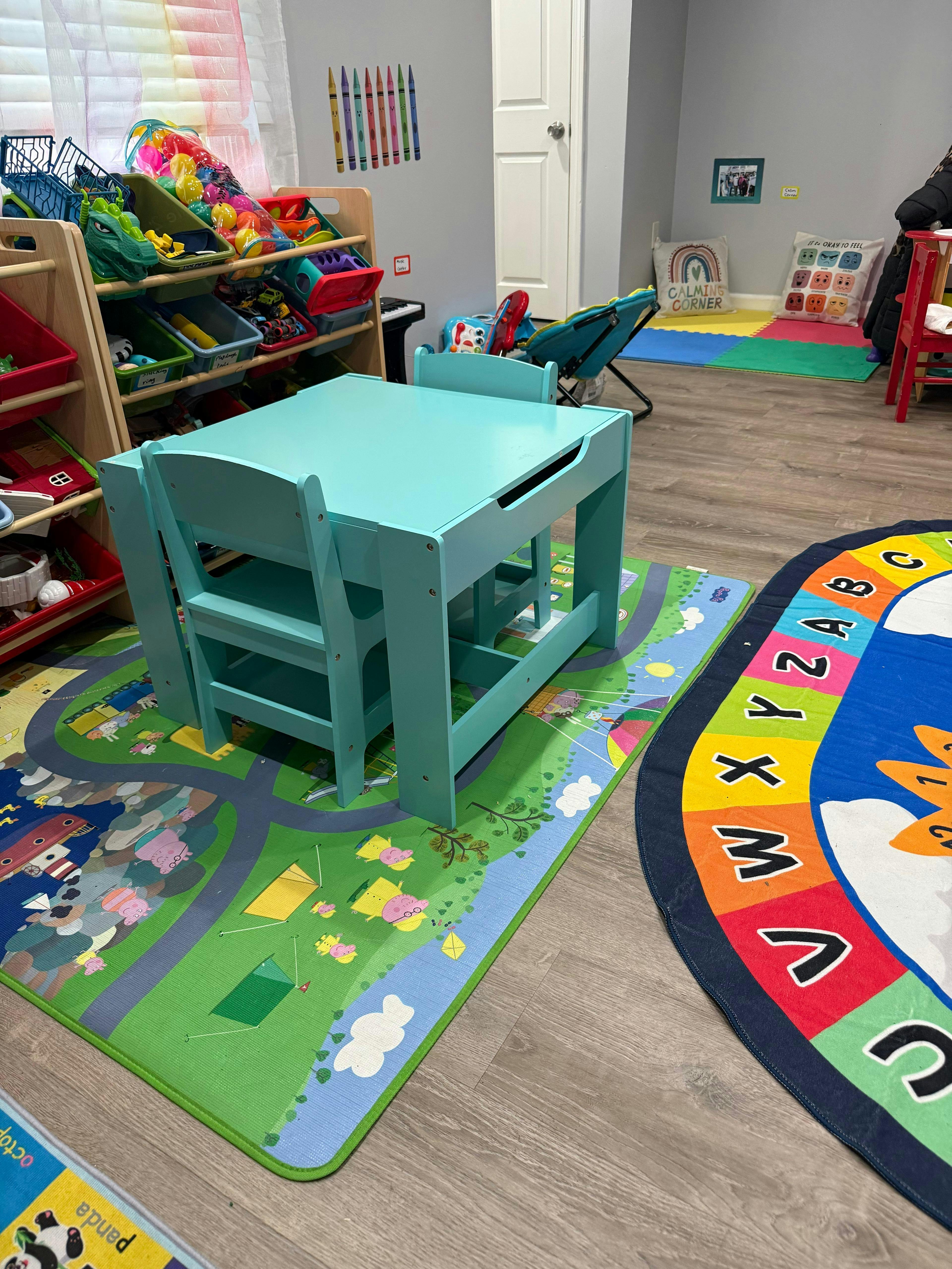 Playroom with a turquoise table and chairs on a road-themed rug