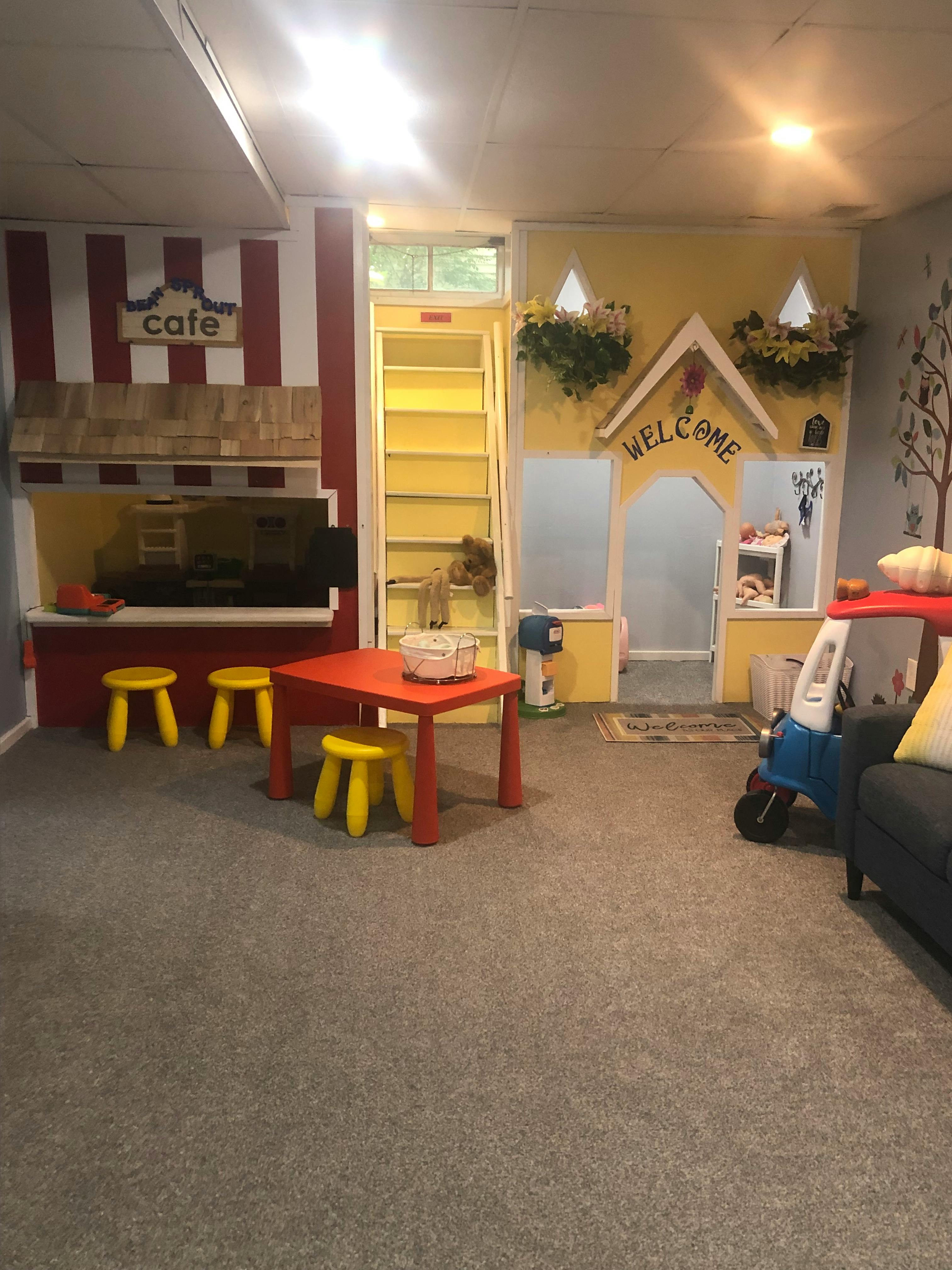 Playroom with a small table and chairs, and a playhouse