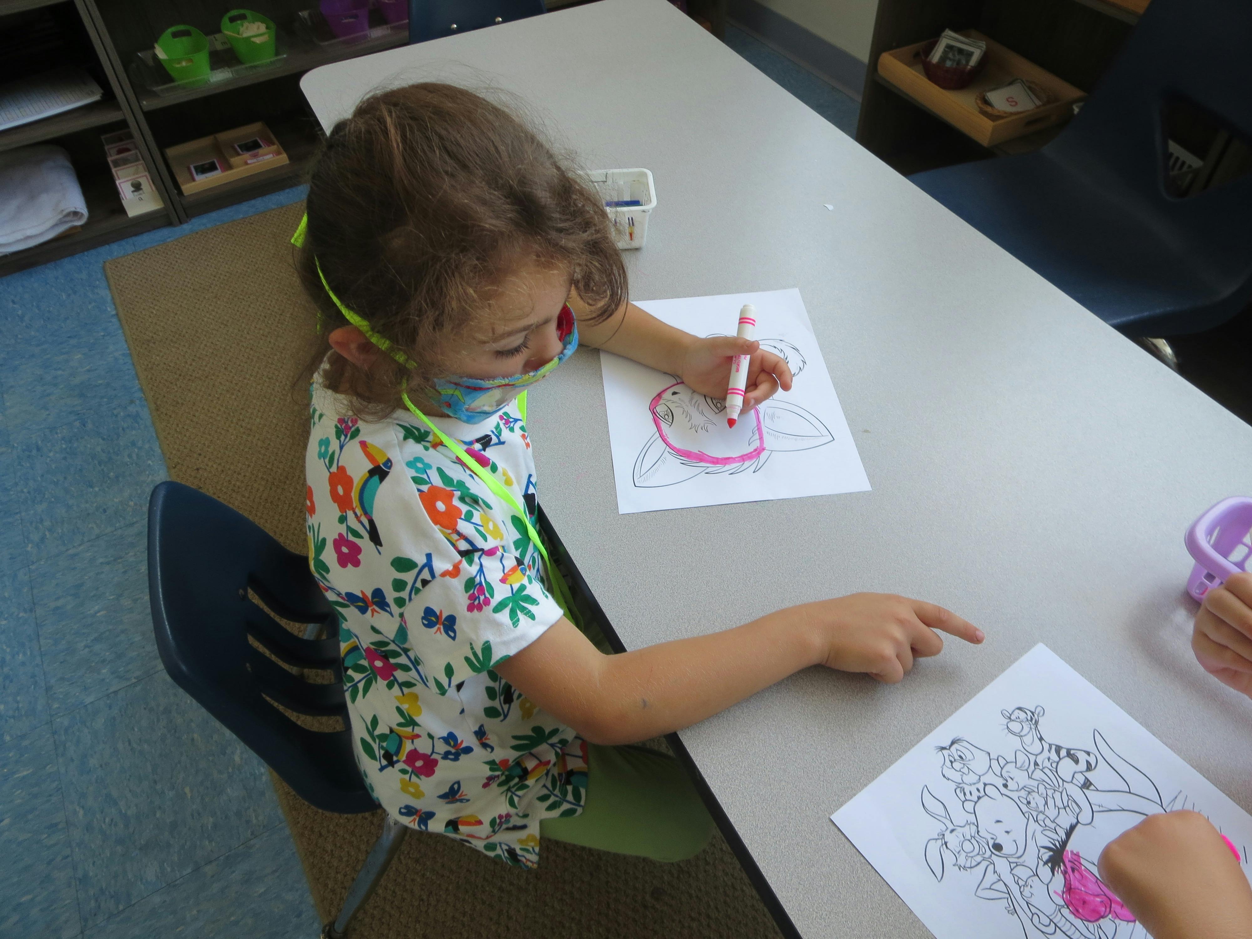 Child coloring a drawing at a table