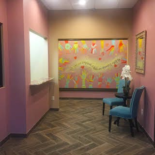 Waiting room with two chairs and a large colorful mural